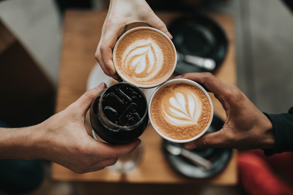 Deux personnes trinquant avec des cafés latte